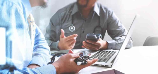 Two doctors debate an issue seated at a conference table