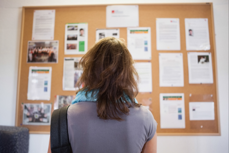Patient reading notices on a bulletin board.
