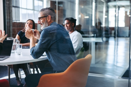 Smiling businessman attending a meeting with his colleagues in an office
