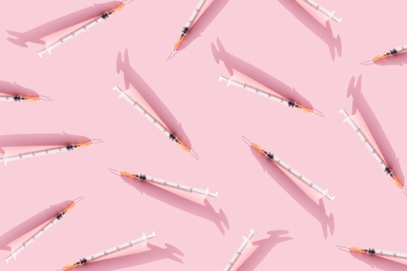 Medical needles on pink background