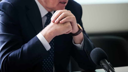 man speaking at microphone during a deposition