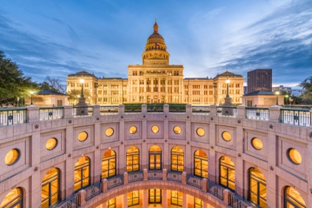 A view of the exterior of the Texas State Capitol at dusk.