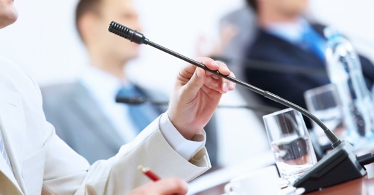 Man talking into microphone at confirmation hearing to discuss the future of Medicare, Medicaid, and Telehealth