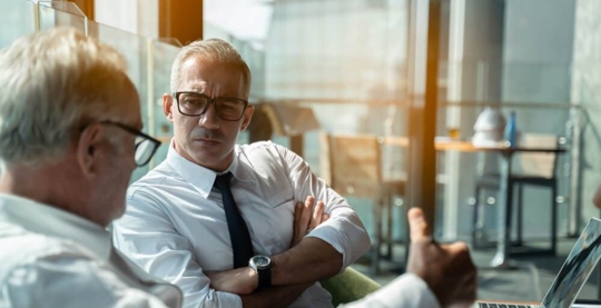 Two businessmen have a discussion about a mergers & acquisitions transaction.