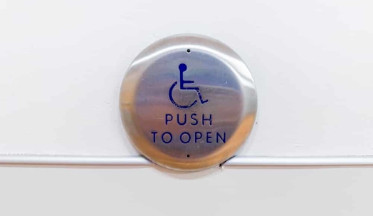 Close-up of a blue and white handicap sign, symbolizing accessibility, inclusivity, and accommodations for individuals with disabilities