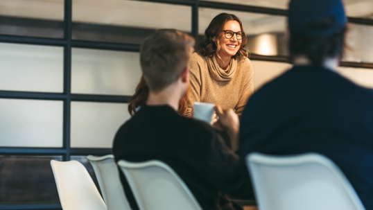 A confident, smiling director leads a board meeting