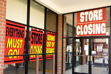 Horizontal shot of 'Store Closing' signs on building