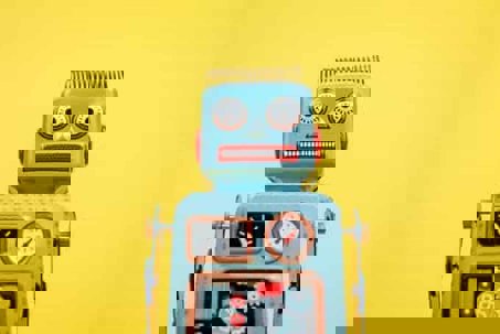 Retro tin robot on a yellow background.