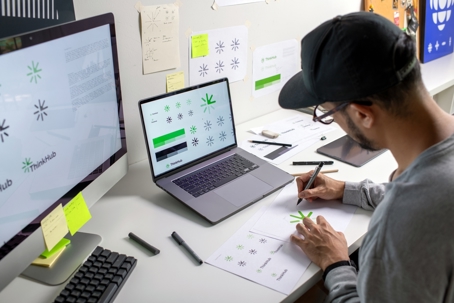 Graphic designer making notes on a logo design at his desk.