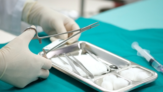 Close-up of doctor preparing sterile surgical instruments for wound care treatment.