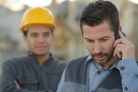 Contractor receiving worrying phone call while on a job site.