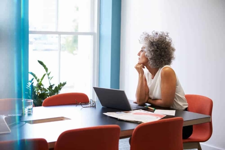 Business woman seated at a conference table and thinking.
