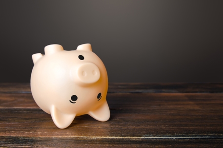 Surprised upside down piggy bank lying on a table.